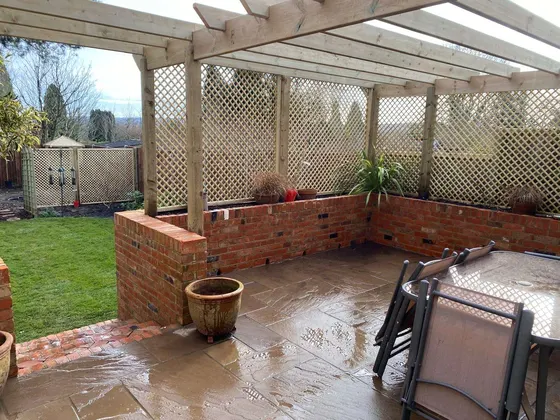 Pergola with trellis over a brick-walled patio