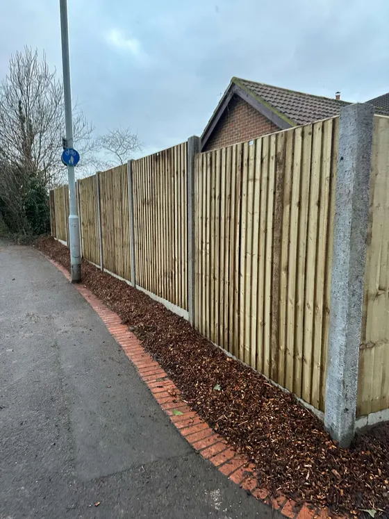 Long run of new closeboard fencing on concrete posts beside a public footpath