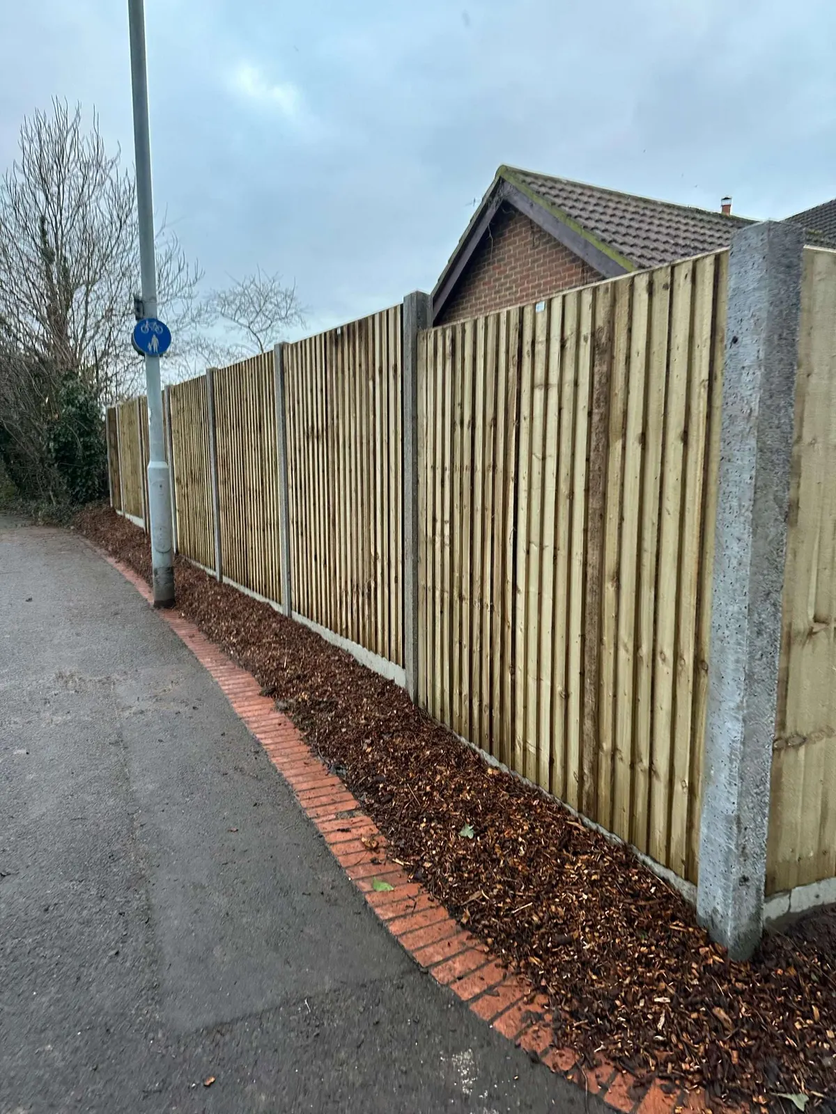 Long run of new closeboard fencing on concrete posts beside a public footpath