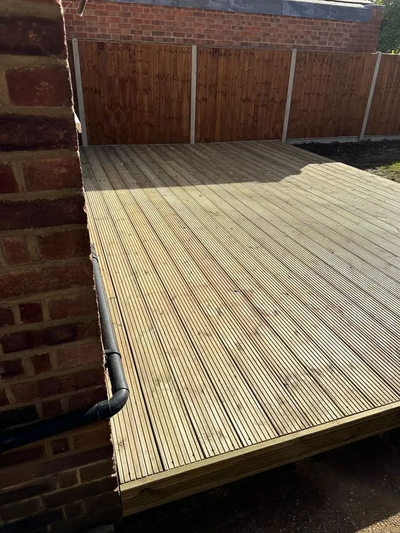 New deck laid up against the back wall of a house