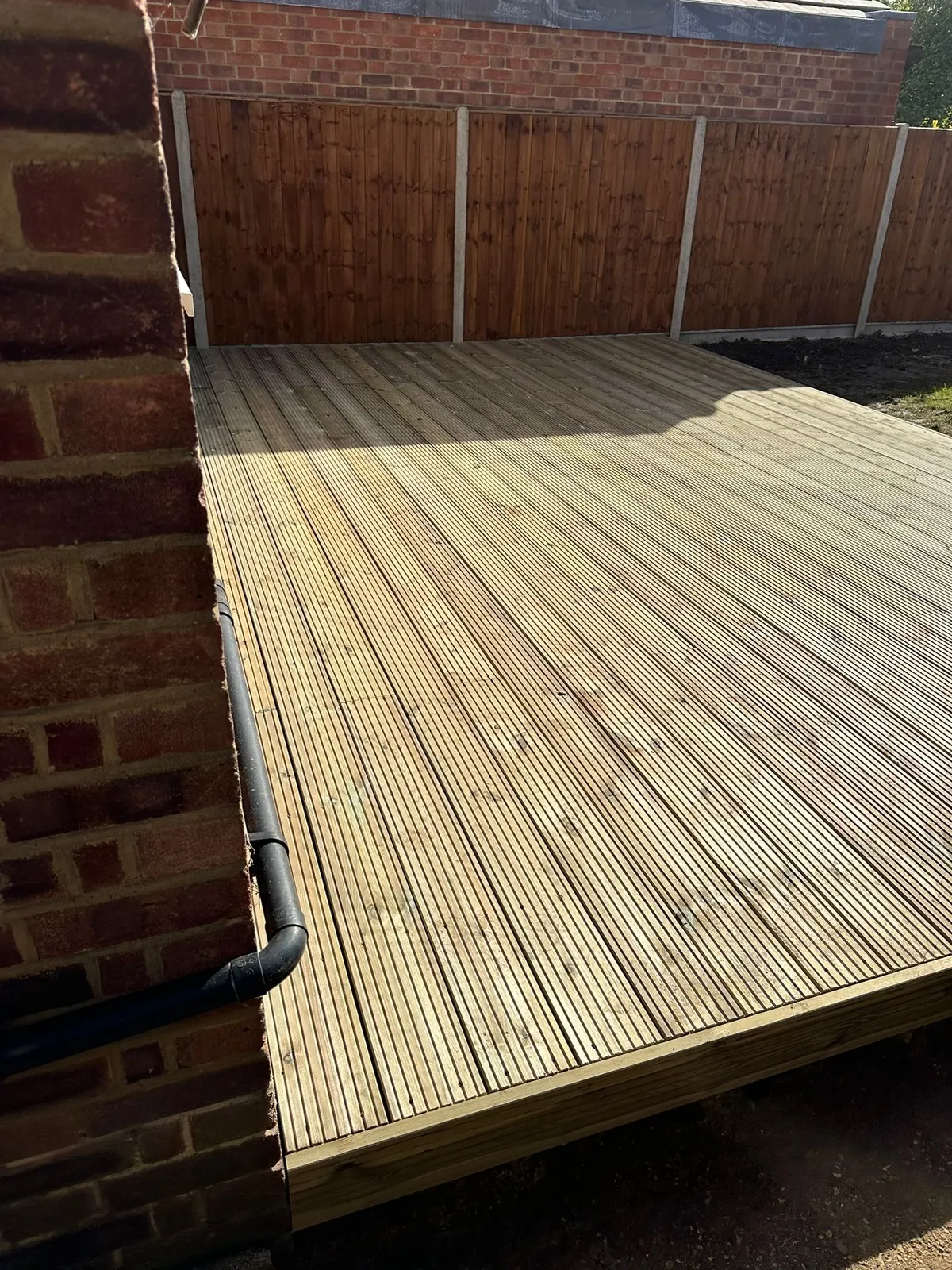 New deck laid up against the back wall of a house