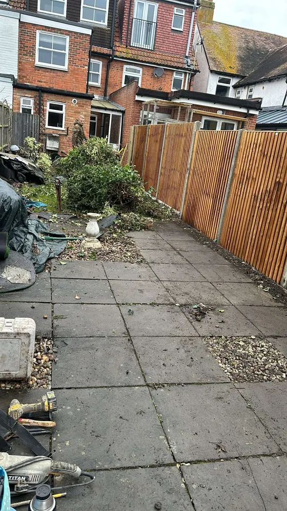 New fence panels running the length of a paved back garden