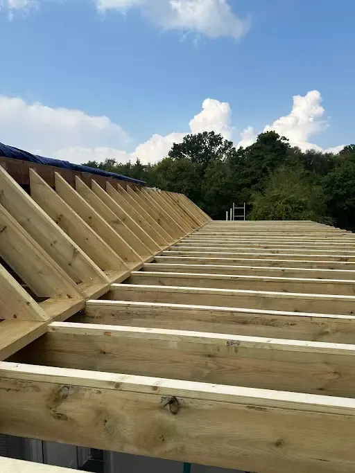 Flat roof joists laid out against a blue sky