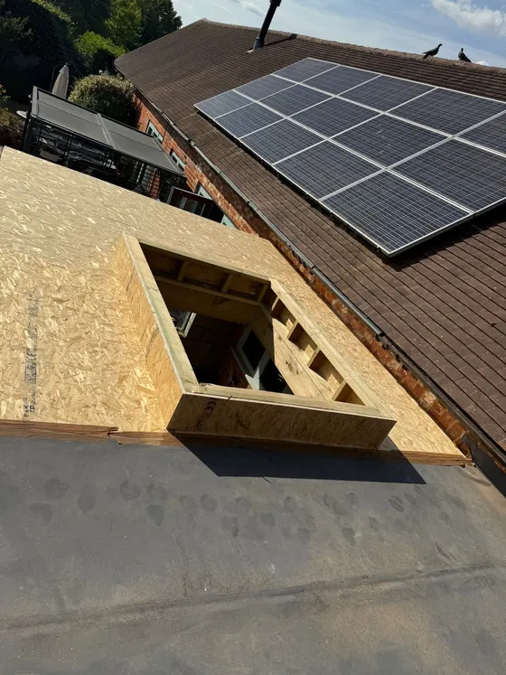Flat roof with a rooflight kerb beside solar panels
