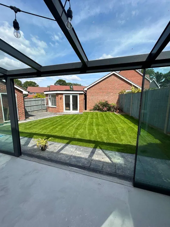 Glass-roofed veranda looking out over a striped lawn