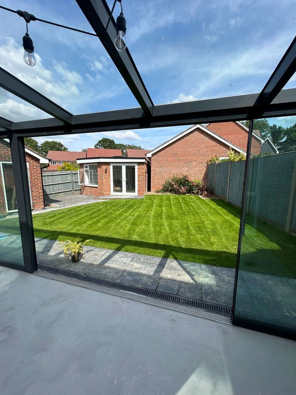 Glass-roofed veranda looking out over a striped lawn