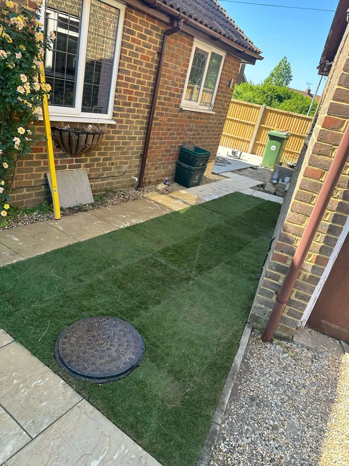 Fresh turf laid in a side garden next to a paved path