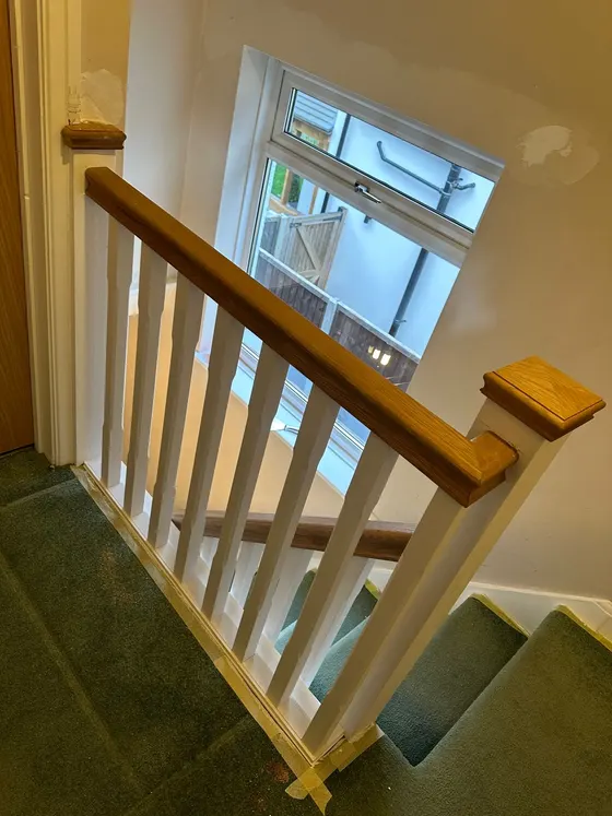 Staircase refurbished with an oak handrail and white spindles