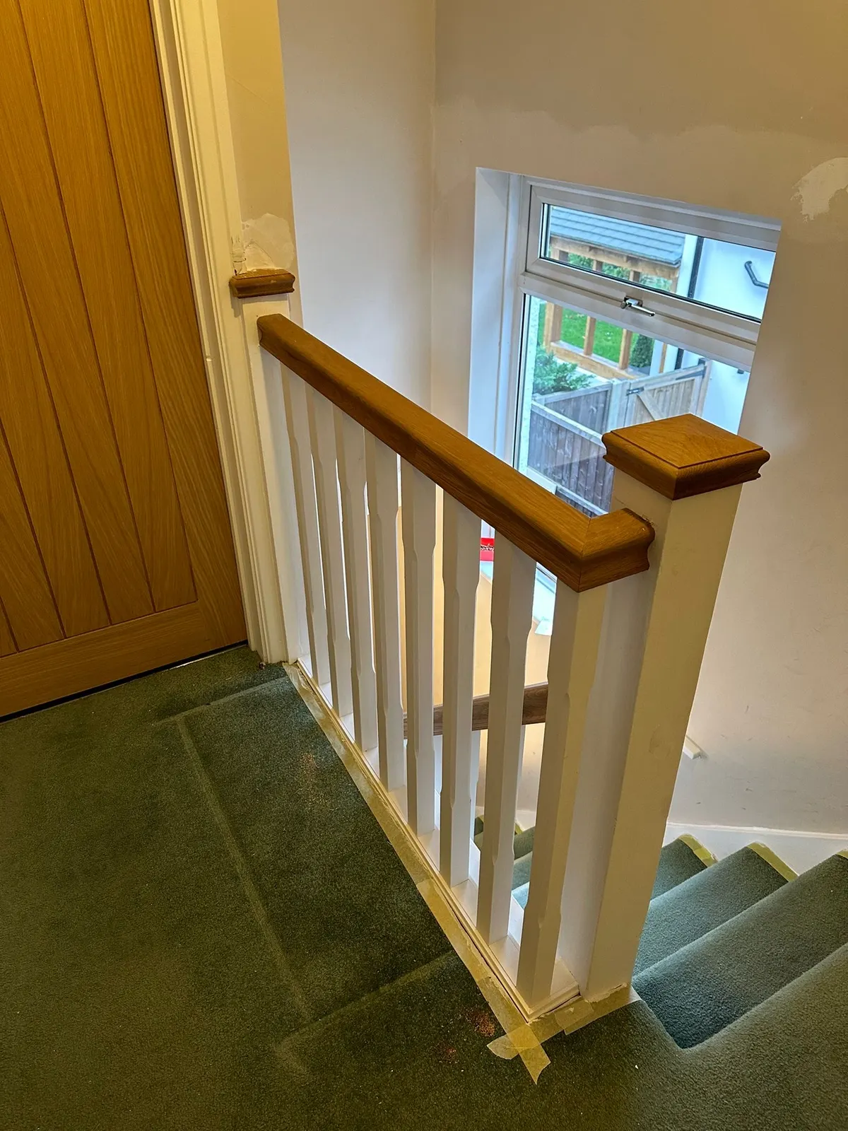Oak newel post and handrail at the foot of a staircase