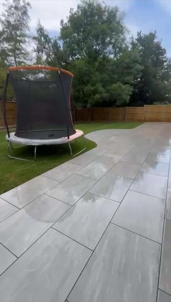 Grey porcelain patio laid across a back garden