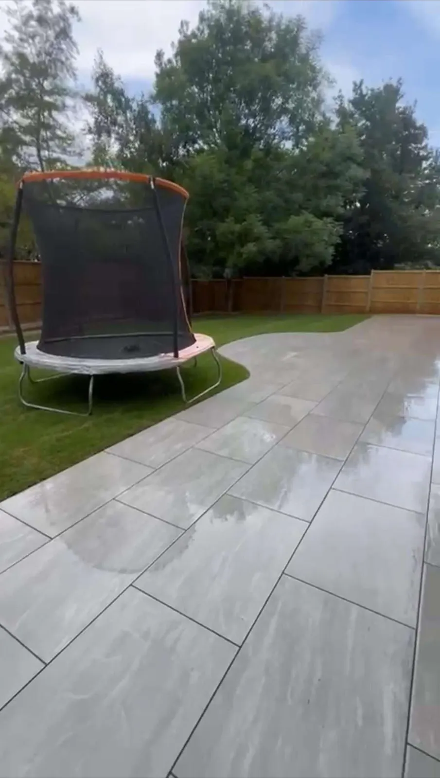 Grey porcelain patio laid across a back garden