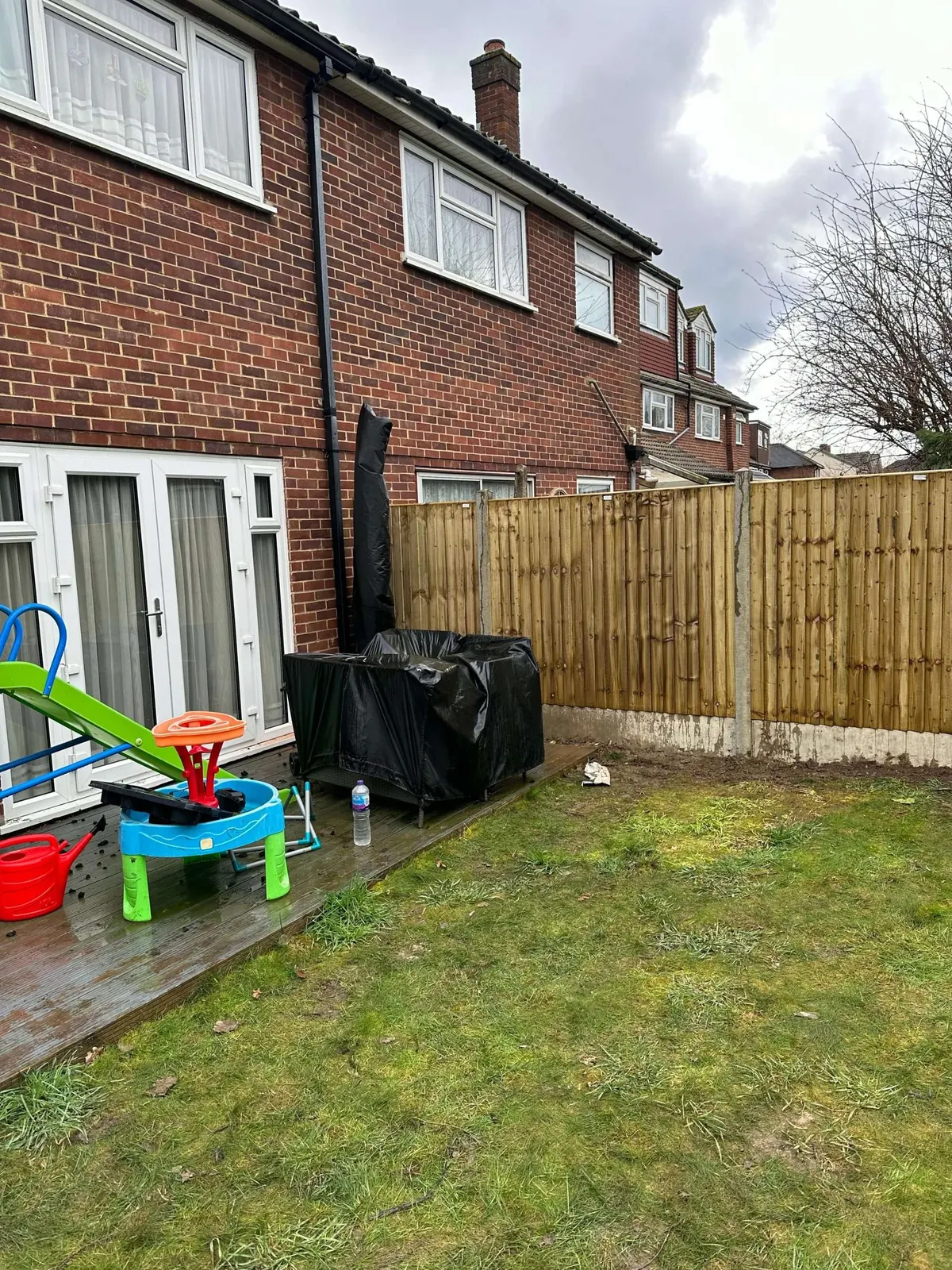 Replaced rear garden fence panels behind a family lawn