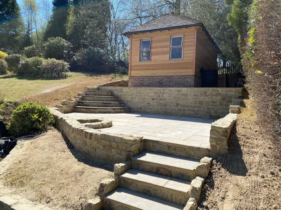 Stone steps and terrace leading up to a cedar garden room