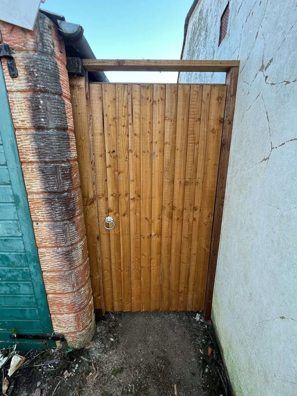 Framed closeboard side gate fitted between two houses