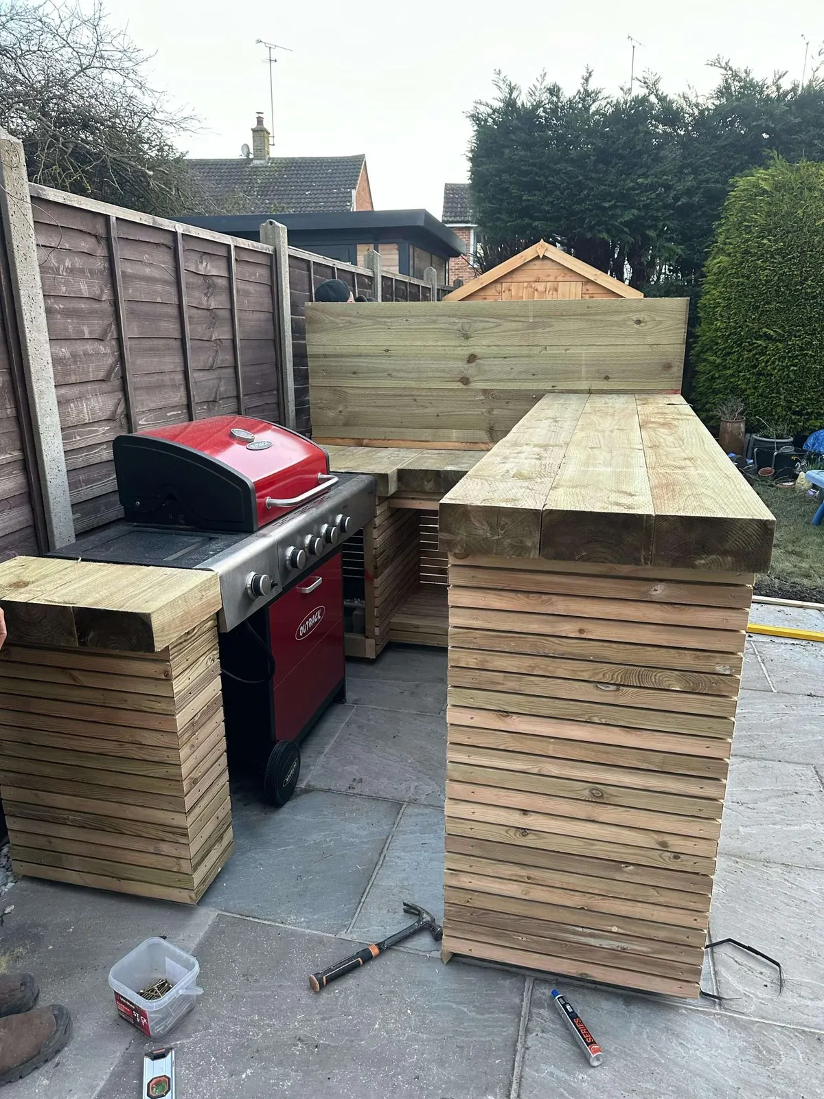Timber outdoor bar built around a barbecue area